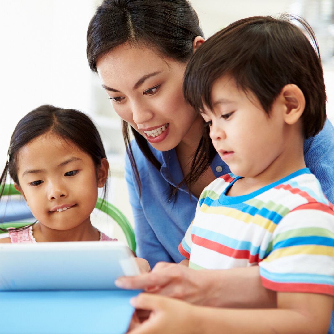22 Mother with two small children, a boy and a girl, looking at an iPad