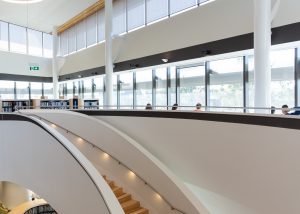 Interior of Bunjil Place Library with state of the art design and wide staircase showing the library split over multiple levels