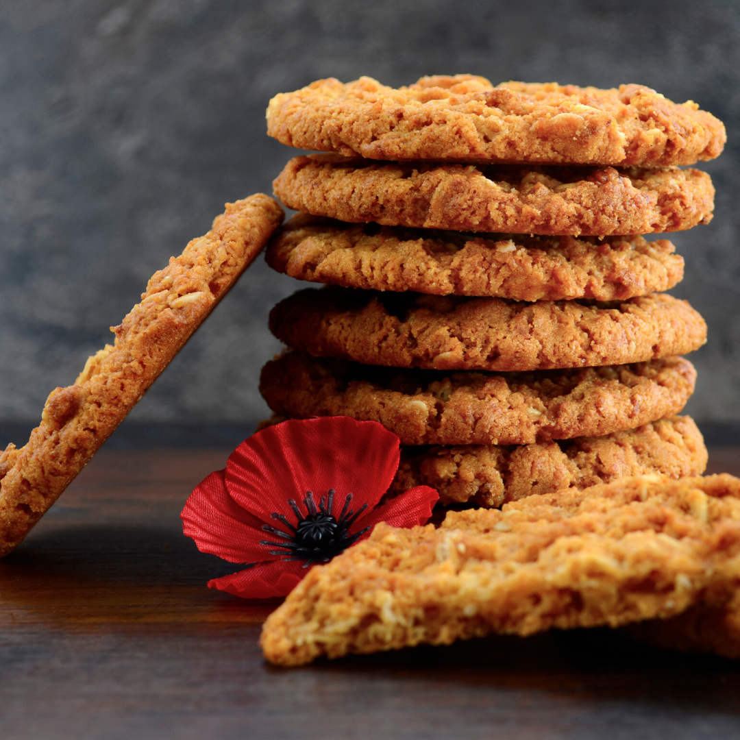 A stack of ANZAC biscuits and a red poppy