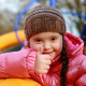 Young girl with disability in a playground giving a thumbs up