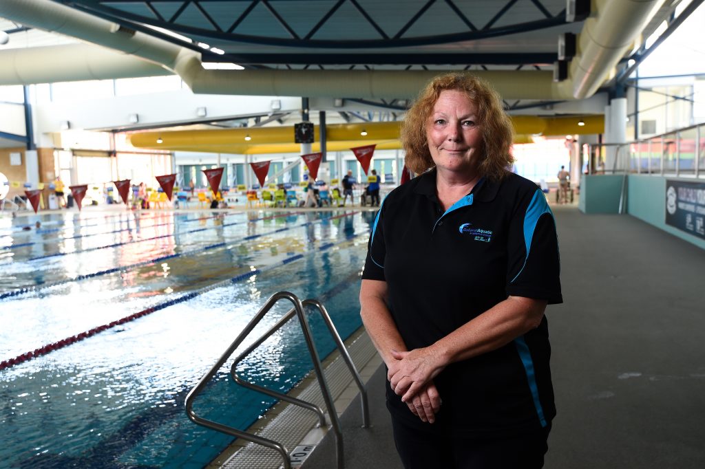 Female staff member standing in front of indoor swimming pool at Ballarat Aquatic and Lifestyle Centre