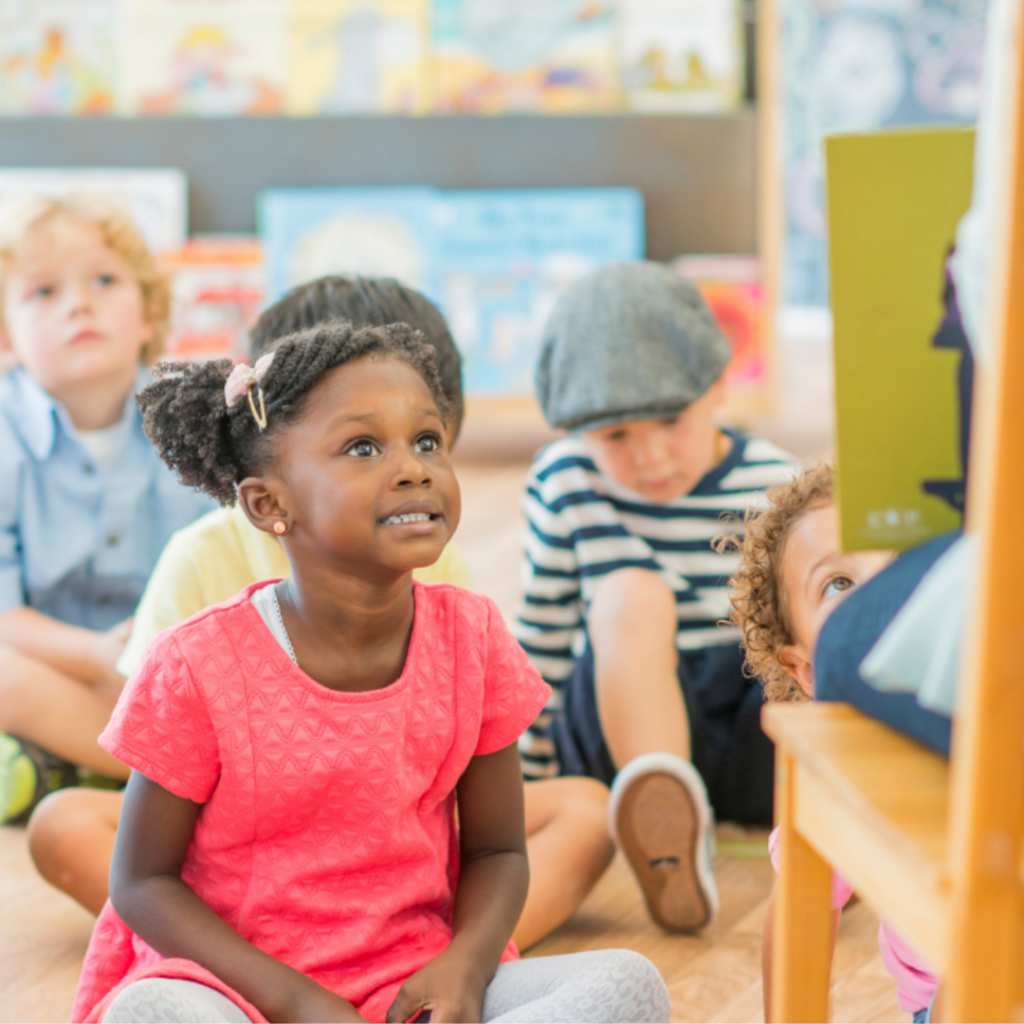 Knox Storytime SS A group of youing children sitting on the library floor listening to a story