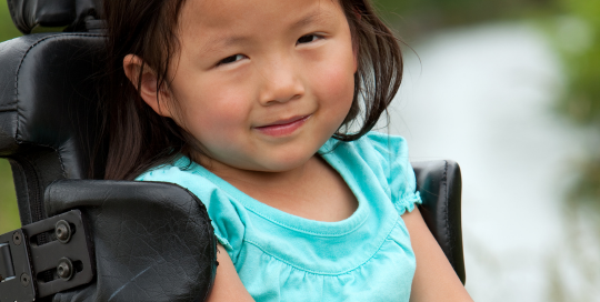 Young asian girl in wheelchair pictured outside