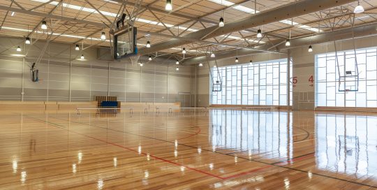 Boroondara Sports Complex indoor basketball stadium with polished wooden floor, lighting, seating and windows