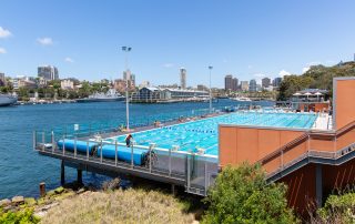 View from above of Andrew Boy Charlton 50m outdoor pool showing harbour in background and water