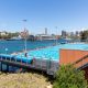 View from above of Andrew Boy Charlton 50m outdoor pool showing harbour in background and water