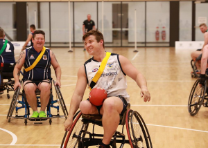 Wheelchair football players taking part in wheechair AFL on indoor court at Diamond Valley Fitness Centre