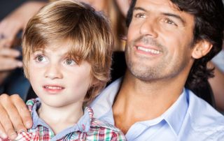 Young boy and his father sitting a theatre watching a live show