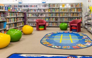 Wallan Library children's section with bookshelves and books, colourful rug on floor anc olourful furniture