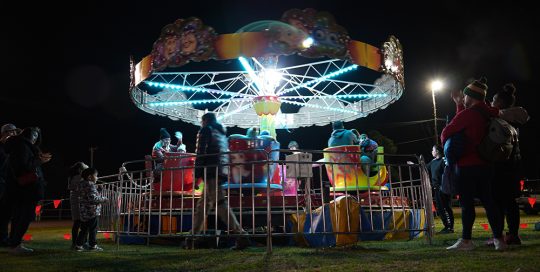 A carnival ride in operation with night sky in background