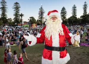 Town of Cambridge Carols by the Lake event with Santa in the foreground and event attendees in the background