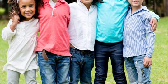 A group of five children standing in a row